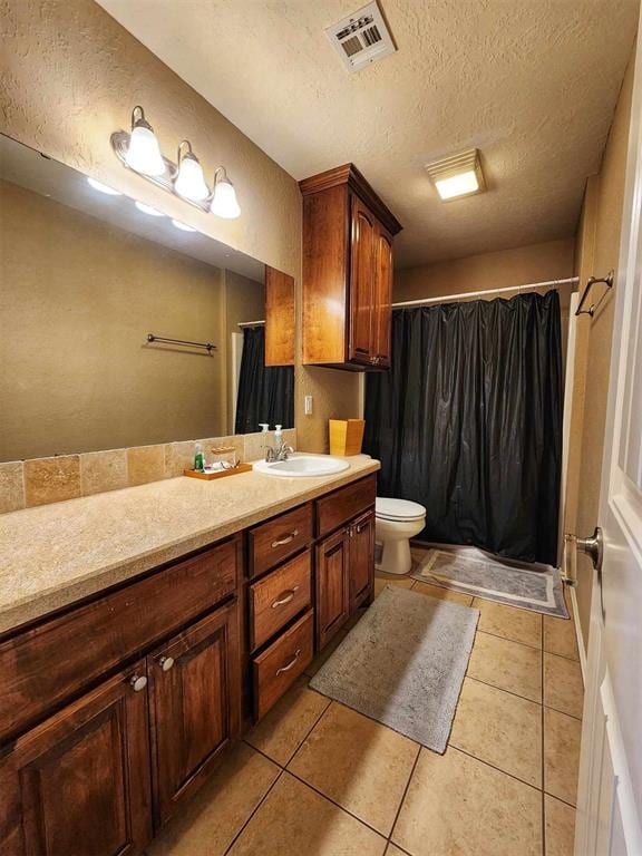 full bath with a textured ceiling, visible vents, tile patterned floors, and vanity