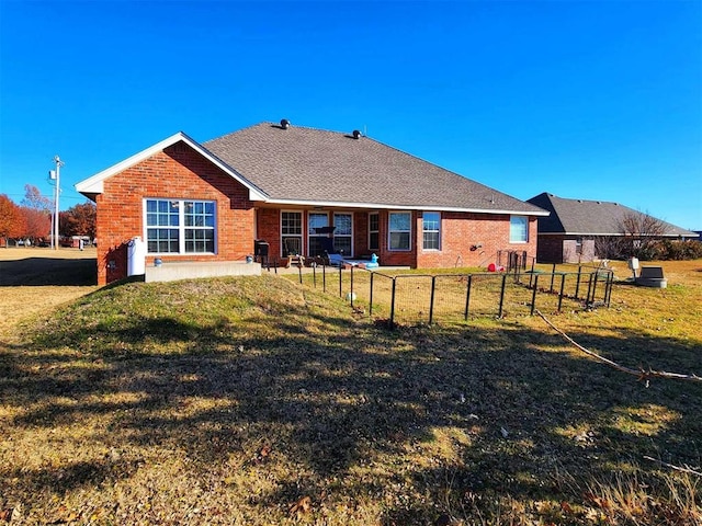 rear view of property featuring a lawn and brick siding