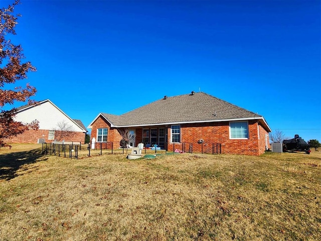 back of property featuring brick siding, a yard, and cooling unit