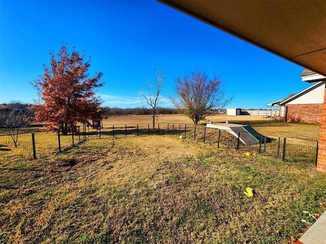 view of yard with fence and an outbuilding