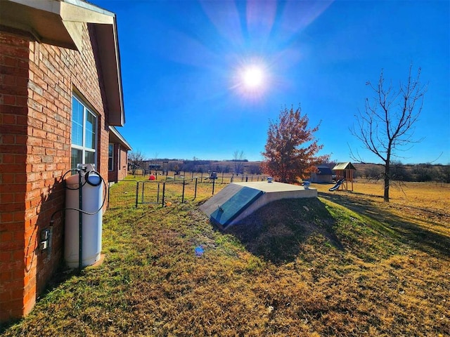 view of storm shelter with a yard and fence