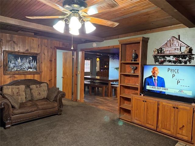 living room with beamed ceiling, wooden walls, wooden ceiling, and a ceiling fan