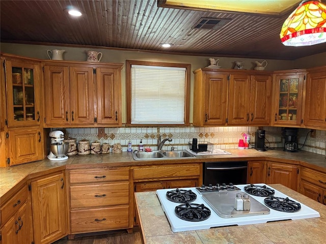 kitchen featuring a sink, decorative backsplash, dishwasher, and white stovetop