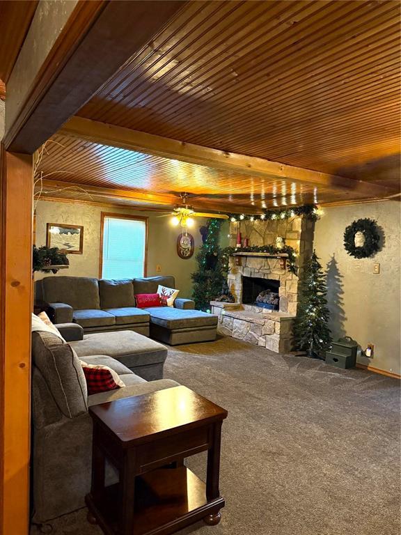 carpeted living room featuring wood ceiling and a fireplace
