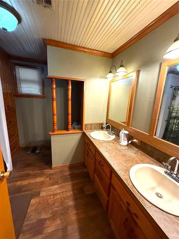 full bathroom featuring wood ceiling, double vanity, wood finished floors, and a sink