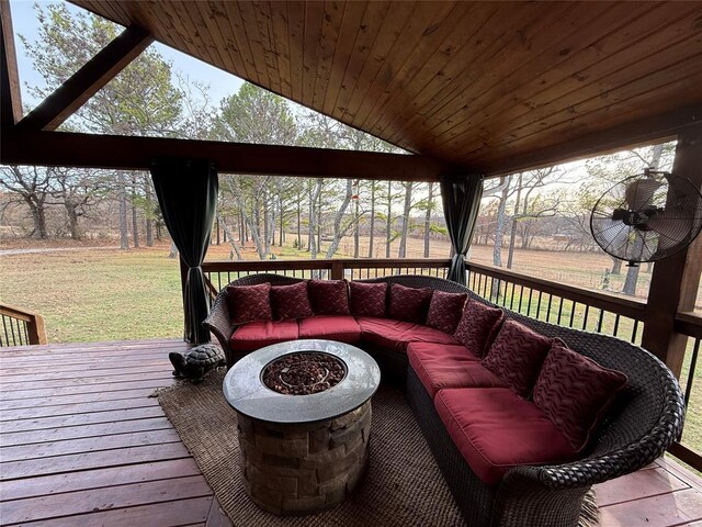 wooden terrace with a lawn and an outdoor living space with a fire pit
