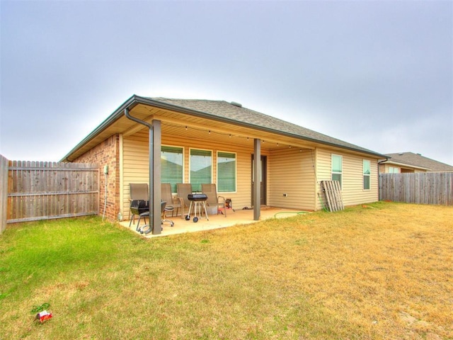 rear view of property with a lawn and a patio