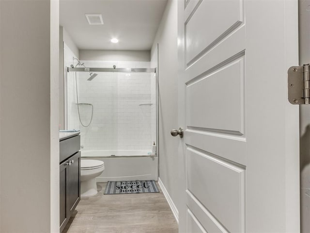 full bathroom with toilet, vanity, combined bath / shower with glass door, and hardwood / wood-style flooring