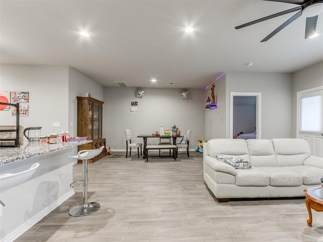 living room featuring light hardwood / wood-style flooring and ceiling fan