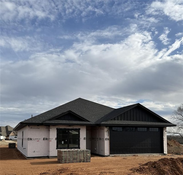 view of front of property featuring a garage and roof with shingles