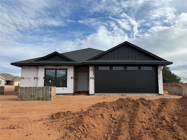 view of front of property featuring a garage, roof with shingles, and board and batten siding