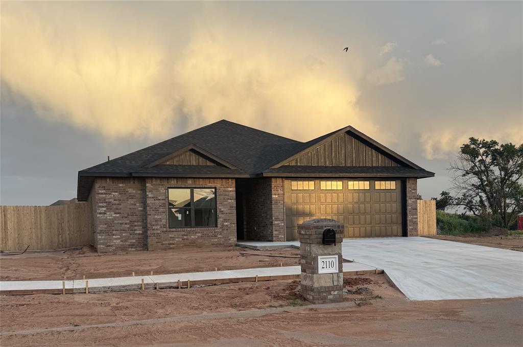 2110 Valley View Rd, Weatherford, OK 73096 - view of front of house featuring a garage, concrete driveway, brick siding, and a shingled roof