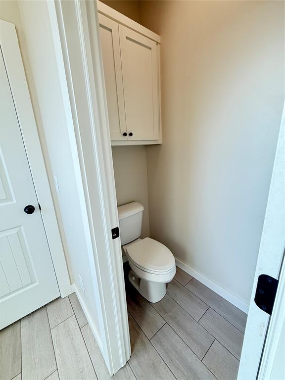 2110 Valley View Rd, Weatherford, OK 73096 - bathroom featuring wood finish floors and toilet