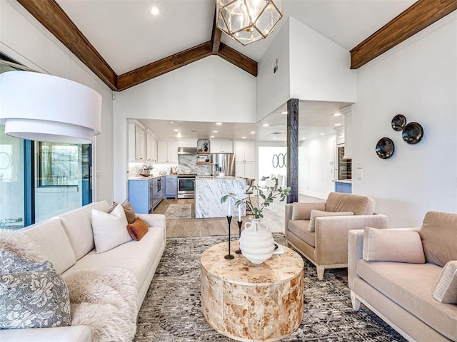 living room with wood-type flooring, high vaulted ceiling, a notable chandelier, and beam ceiling