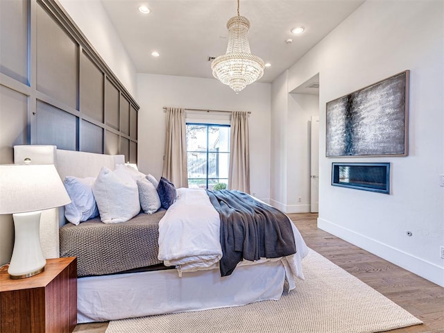 bedroom featuring hardwood / wood-style flooring and a chandelier