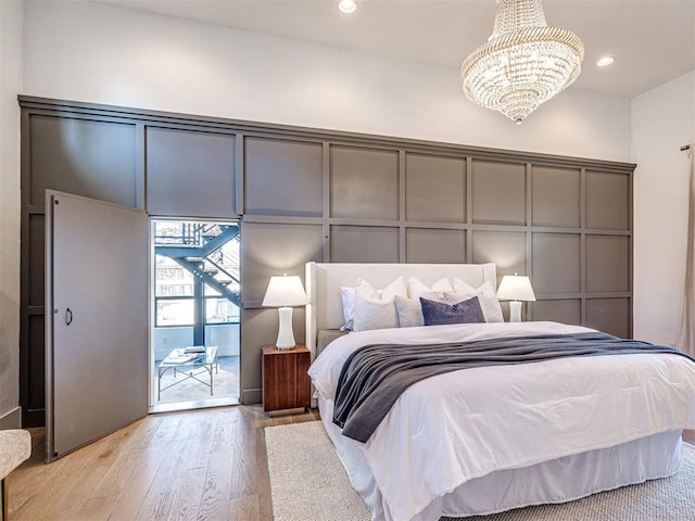 bedroom with an inviting chandelier and light hardwood / wood-style flooring