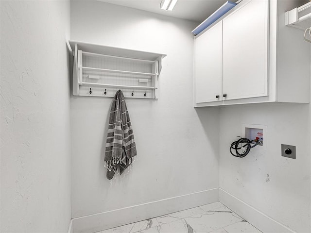 clothes washing area with electric dryer hookup, hookup for a washing machine, and cabinets