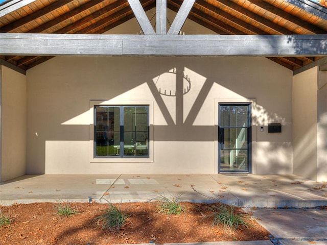 view of exterior entry with a patio