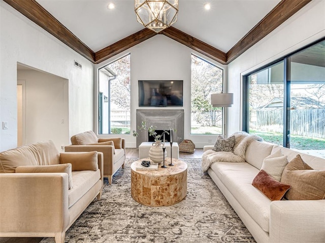 living room featuring an inviting chandelier and lofted ceiling with beams