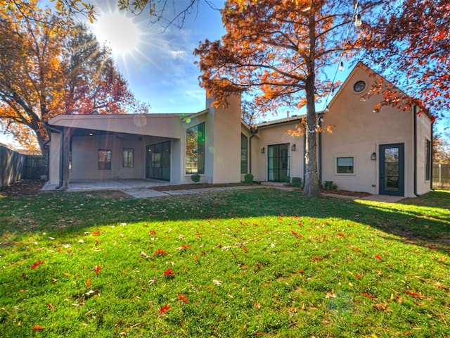 rear view of property featuring a lawn and a patio