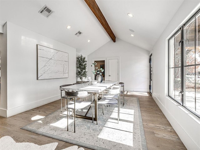 dining area with light hardwood / wood-style floors and lofted ceiling with beams