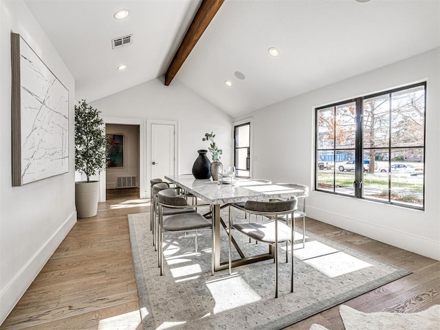 dining room featuring vaulted ceiling with beams and light wood-type flooring