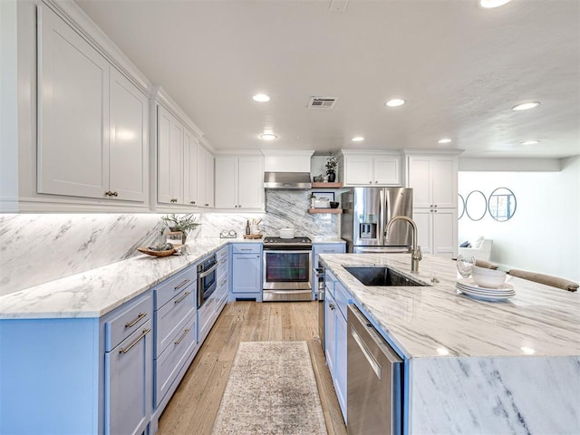 kitchen with sink, ventilation hood, white cabinets, and appliances with stainless steel finishes