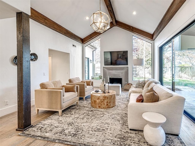 living room with an inviting chandelier, beam ceiling, high vaulted ceiling, and light wood-type flooring