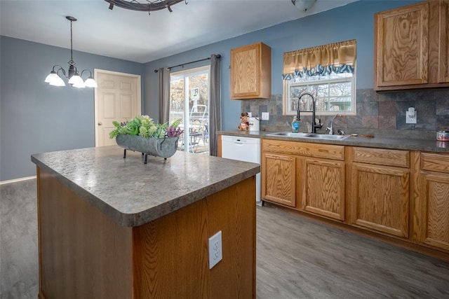 kitchen with sink, dishwasher, a chandelier, dark hardwood / wood-style floors, and a kitchen island