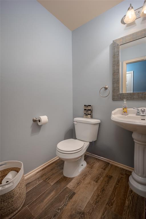 bathroom featuring wood-type flooring and toilet