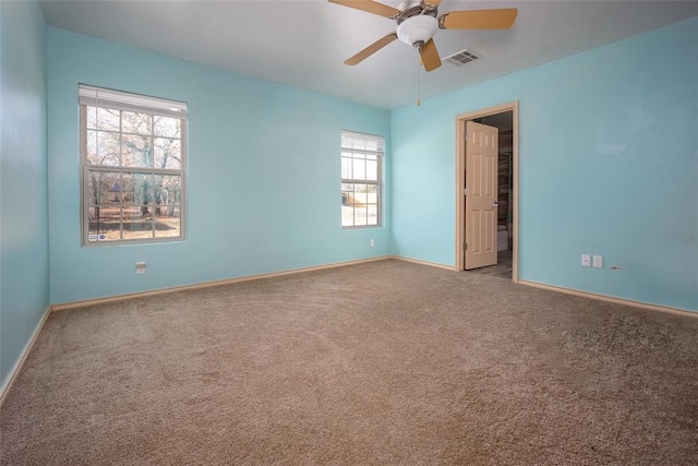 carpeted spare room featuring ceiling fan