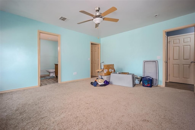 interior space with ceiling fan, light colored carpet, and connected bathroom