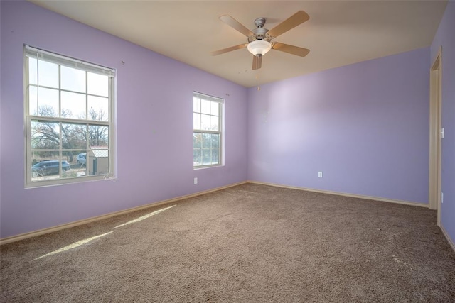 carpeted spare room featuring ceiling fan