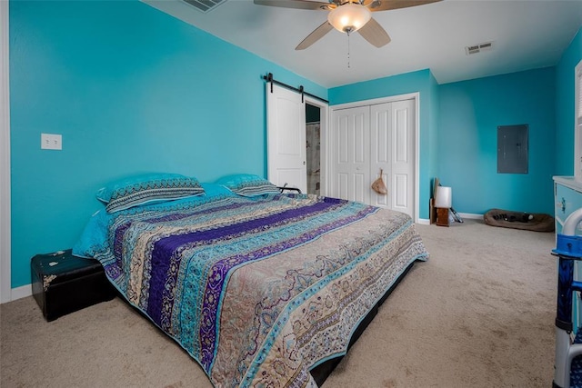 carpeted bedroom featuring ceiling fan, a barn door, electric panel, and a closet