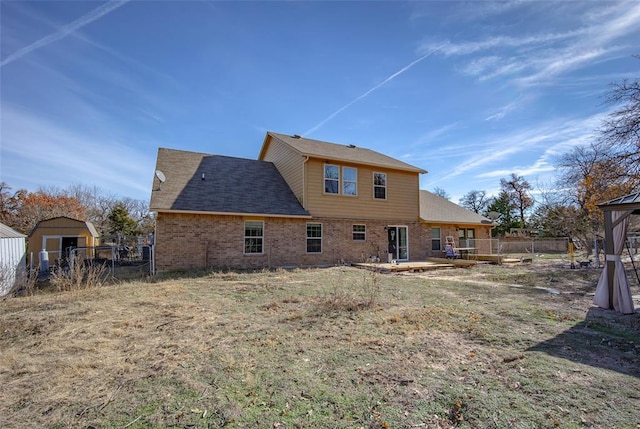 back of house with a yard, a patio, and a storage unit