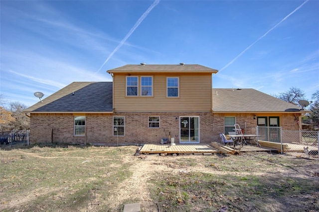 back of property with a deck and a lawn