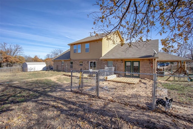 rear view of property with a storage shed