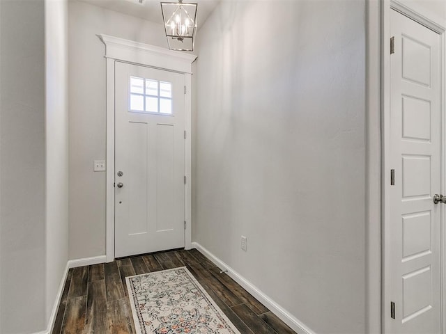 foyer featuring dark wood-type flooring and a chandelier