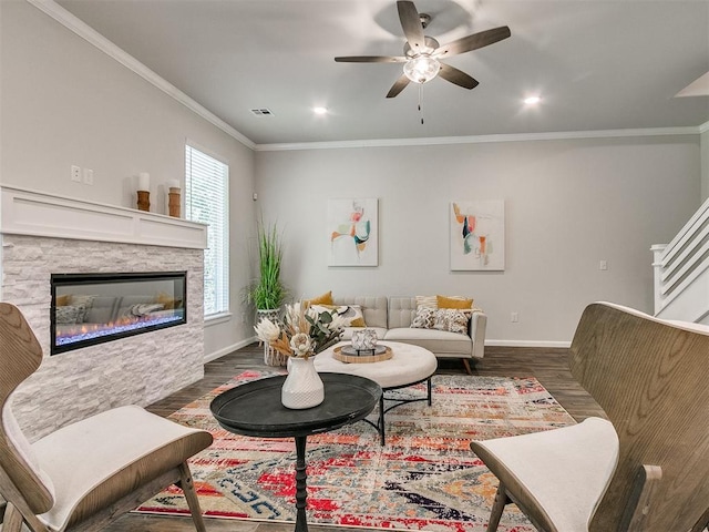 living room featuring ceiling fan, a fireplace, dark wood-type flooring, and ornamental molding