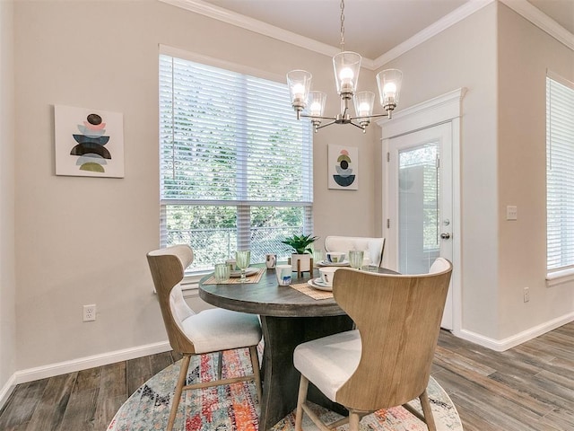 dining space with dark hardwood / wood-style flooring, ornamental molding, and a notable chandelier