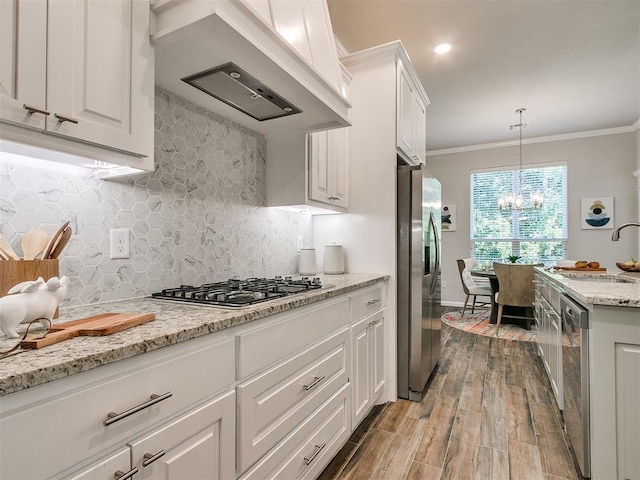 kitchen with white cabinets, custom exhaust hood, appliances with stainless steel finishes, and light hardwood / wood-style flooring