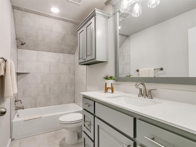 full bathroom featuring tile patterned floors, vanity, tiled shower / bath combo, and toilet