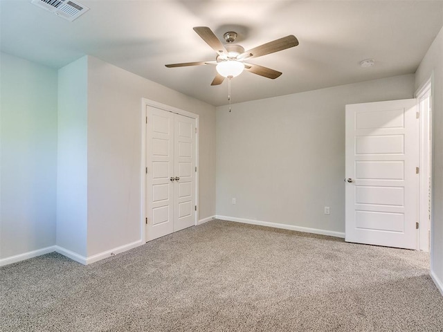 unfurnished bedroom with carpet, a closet, and ceiling fan