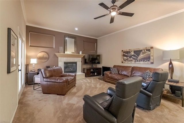 living room with a tiled fireplace, light carpet, ceiling fan, and ornamental molding