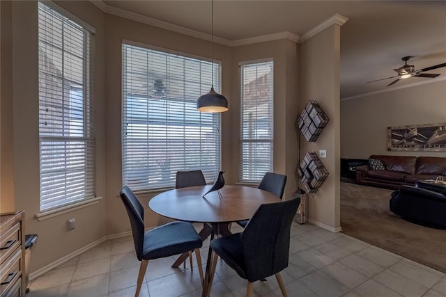 dining area featuring ceiling fan, crown molding, and light colored carpet