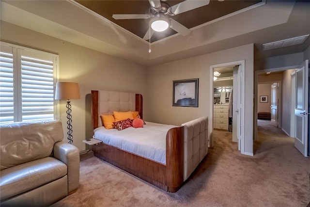 carpeted bedroom with a tray ceiling and ceiling fan