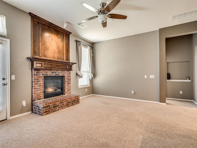 unfurnished living room featuring a brick fireplace, carpet flooring, and ceiling fan