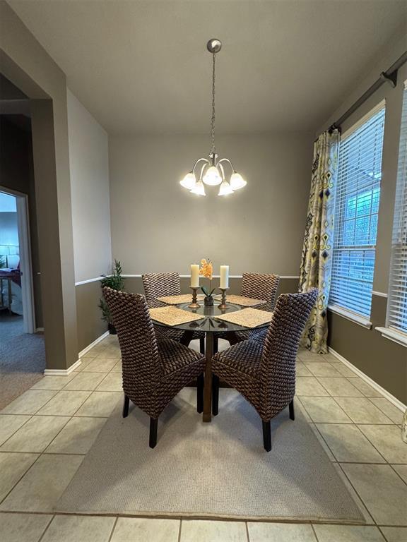 dining area with an inviting chandelier and light tile patterned floors