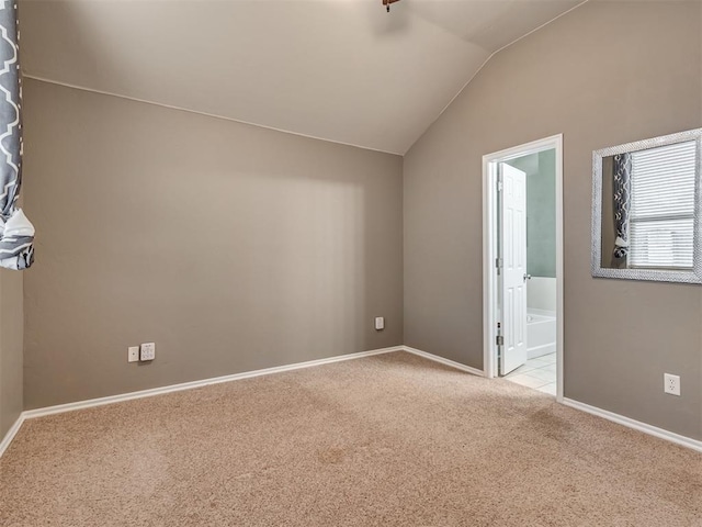 additional living space with light colored carpet and vaulted ceiling