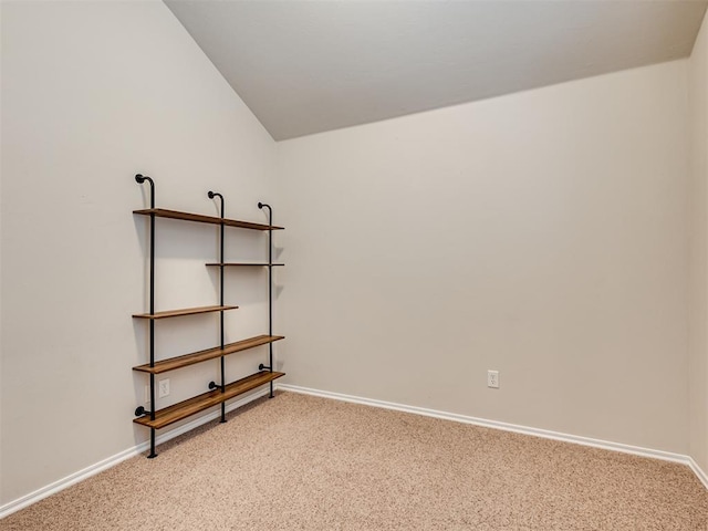 empty room with lofted ceiling and carpet floors